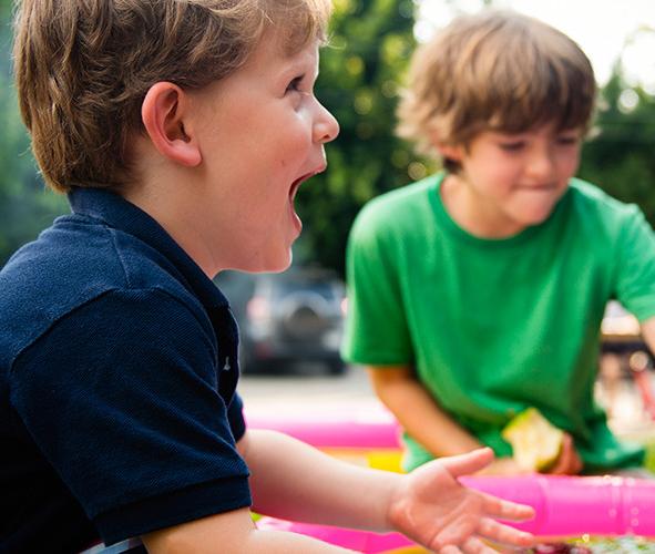 Toddlers playing with toys on a green lawn 